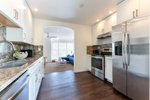 full kitchen with oven, fridge, toaster, microwave and coffee maker.
