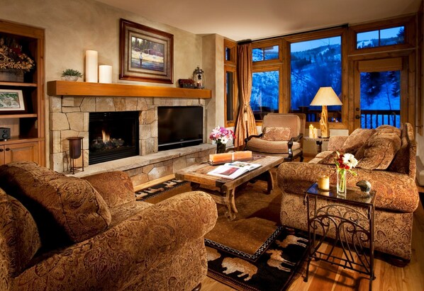 Relax in the luxurious living area, complete with fireplace. Please note that views may vary.