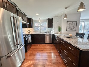 Modern kitchen -stainless steel appliances and granite counter top and island
