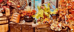 A charming entryway dressed in cozy fall decor , with pumpkins, colorful leaves ,and warm, inviting touches that welcome you in.