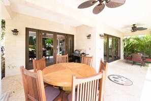 Veranda furnished with a table for six, gas grill, and lounge area.