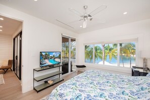 Primary Suite with king bed, television, and waterfront views. 