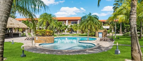 Refreshing tropical Pool Area of the 3BR Condo in Oranjestad Aruba - Relax by the shimmering poolside oasis - Comfort at its best - Enjoy leisurely moments in inviting pool area - Palm trees and tropical plants enhance the vacation feel