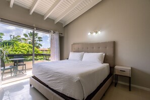 Deluxe Bedroom of the Apartment in Oranjestad Aruba - King size comfy Bed - Minimalist decor, creating a clean and uncluttered sleeping space - Private Balcony - Outstanding outside Views