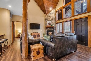 This rustic living room greets you with the knotty pine vaulted ceiling!