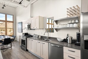 A well stocked kitchen next to the dining room in the living room.