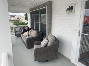 Covered front porch with comfortable sofa and chairs