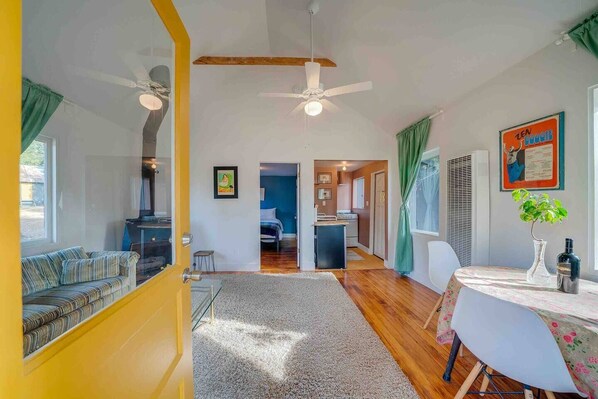 Living room with table for dining, gas heater and fireplace.