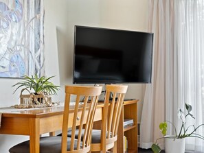 Living room essentials: comfy furniture, a flat-screen television & a touch of greenery.