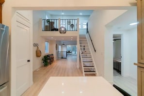 View from the kitchen to the main living area, bedroom hallway, and loft space