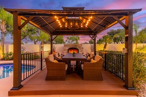 Lit cabana with outdoor fireplace