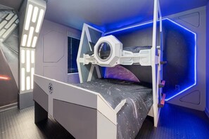 Blast off into adventure with this space-themed bedroom, complete with a spacecraft bunk bed and cosmic decor!