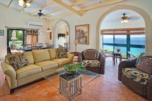 Comfortable living room with plenty of seating for everyone.  Overlooks the pool deck and sea