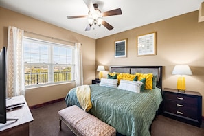 Comfortable King Bed in the guest room with city views. TV mounted on the wall