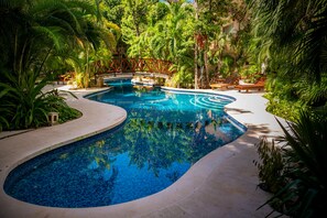 A beautiful azure pool winds through the complex and has loungers to relax.