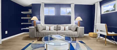 Living space, featuring vibrant navy walls, modern furnishings.