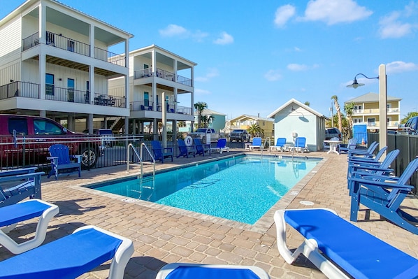 Communal Pool with heating option has plenty lounge chairs available for relaxation! The pool is visible from the deck and steps to the door.