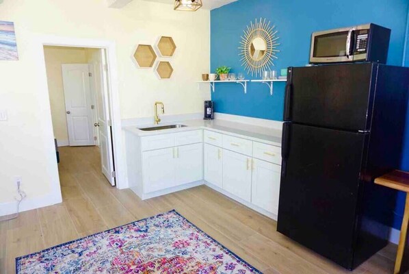 Fully stocked kitchen with toaster oven, microwave, 2 burner cooktop, and all cooking utensils and silverware.