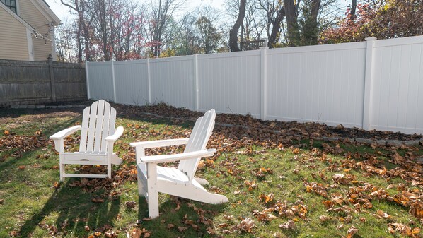 Relax on the Adirondack chairs in this spacious fenced in backyard