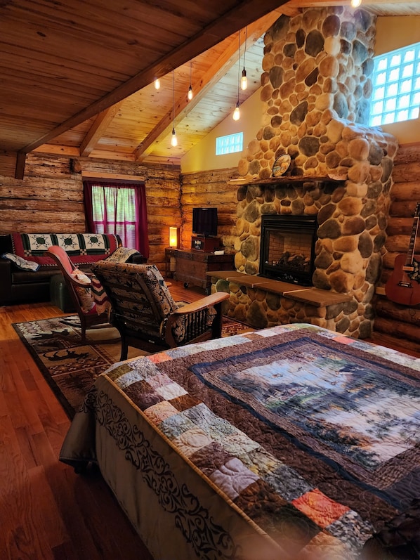 Main Log Room w/ Queen size bed, couch, antique rockers, TV and gas fireplace