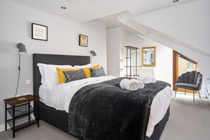 Bedroom 1: The master bedroom features a comfy king-sized bed adorned in crisp white linen.