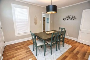 The dining room table contains 4 chairs and a seating bench on the opposite side.