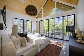 Primary Master Bedroom: Sun-drenched retreat with forest views and stylish, modern decor!