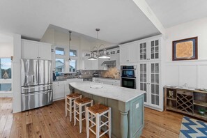 Cook up family favorites in this gorgeous chef's kitchen featuring stainless steel appliances, an icemaker, and an eat-at counter.