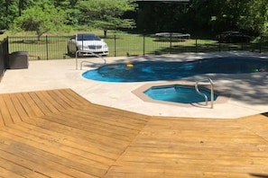 inground heated pool with diving board and hottub