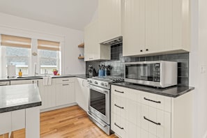 Gas range & oven; handmade kitchen tile backsplash & custom-built cabinets