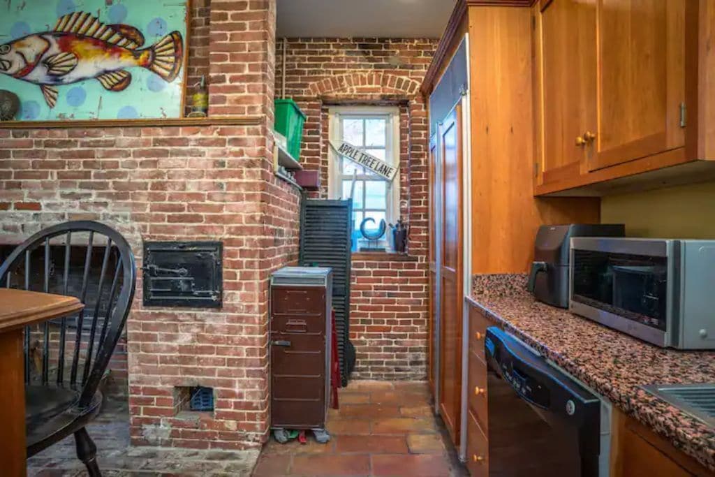 A fun painting of a fish hangs on a historic hearth at a New Hampshire vacation rental.