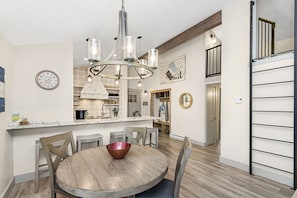 Dining room area with seating for 4 and additional seats at the kitchen barstools