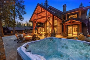 Soak in the hot tub beside a glowing fire pit and dramatic timber canopy.