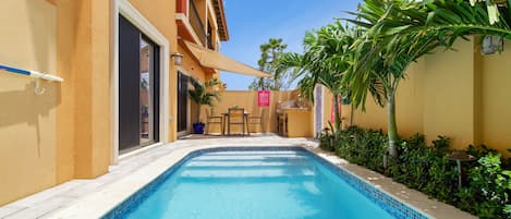 Resplendent Pool Area of the Apartment in Noord Aruba - Greenery for a secluded feel - Provides a relaxed atmosphere for unwinding - Space for swimming, games, and activities - Poolside perfect for sunbathing and relaxation