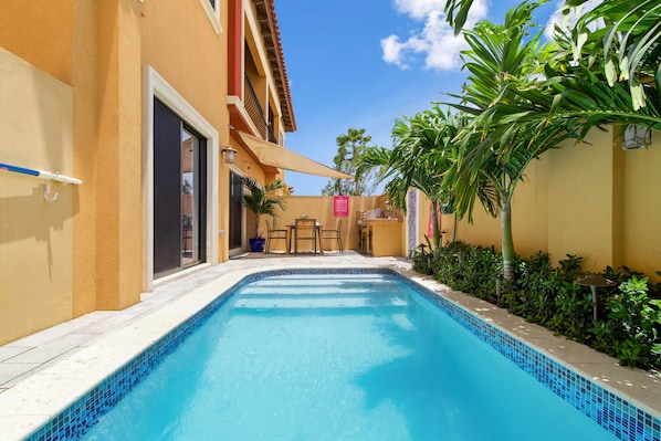 Resplendent Pool Area of the Apartment in Noord Aruba - Greenery for a secluded feel - Provides a relaxed atmosphere for unwinding - Space for swimming, games, and activities - Poolside perfect for sunbathing and relaxation