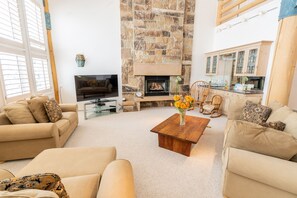 living area with wet bar and view windows and deck