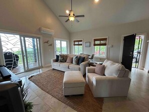 Cozy living area with sofa bed, AC, ceiling fans and TV