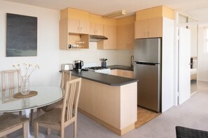 Fully equipped kitchen with pots, pans, coffee machine, oils and spices