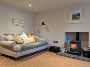 Relax in the lounge on the large sofa with log burner
