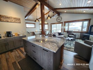 A large island in the kitchen helps to prepare food. 