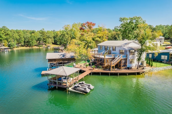 House surrounded by water on three sides, large dock area.