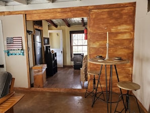 Living Room into the Kitchen, with bar style seating dining table