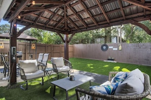 Relaxing outdoor area with lighted Gazebo, seating and fenced yard