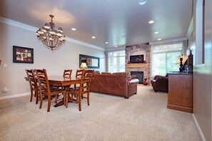 Experience the cozy living room, outfitted with plush seating, an expansive smart TV, and patio doors that frame the breathtaking mountain vistas.