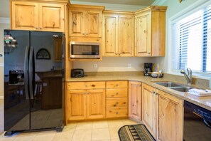 Indulge in culinary delights in the cozy kitchen, equipped with ample amenities for creating wonderful dinners with friends and family.