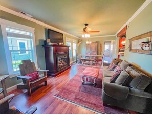 Comfortable and tastefully decorated living room with gas fireplace, dining, Roku TV, DVD player, with pull out sofa.