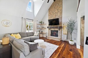 Great room with hardwood floors and stone fireplace. 