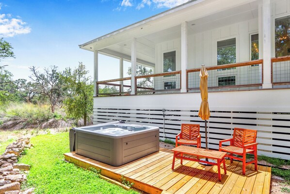 Private hot tub with seating at the back of the home