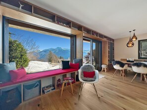 Baie vitrée avec petite banquette pour profiter de la vue