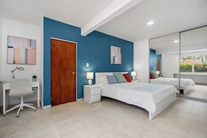Experience the elegance of our stylish room, featuring a luxurious  bed and a mirror.